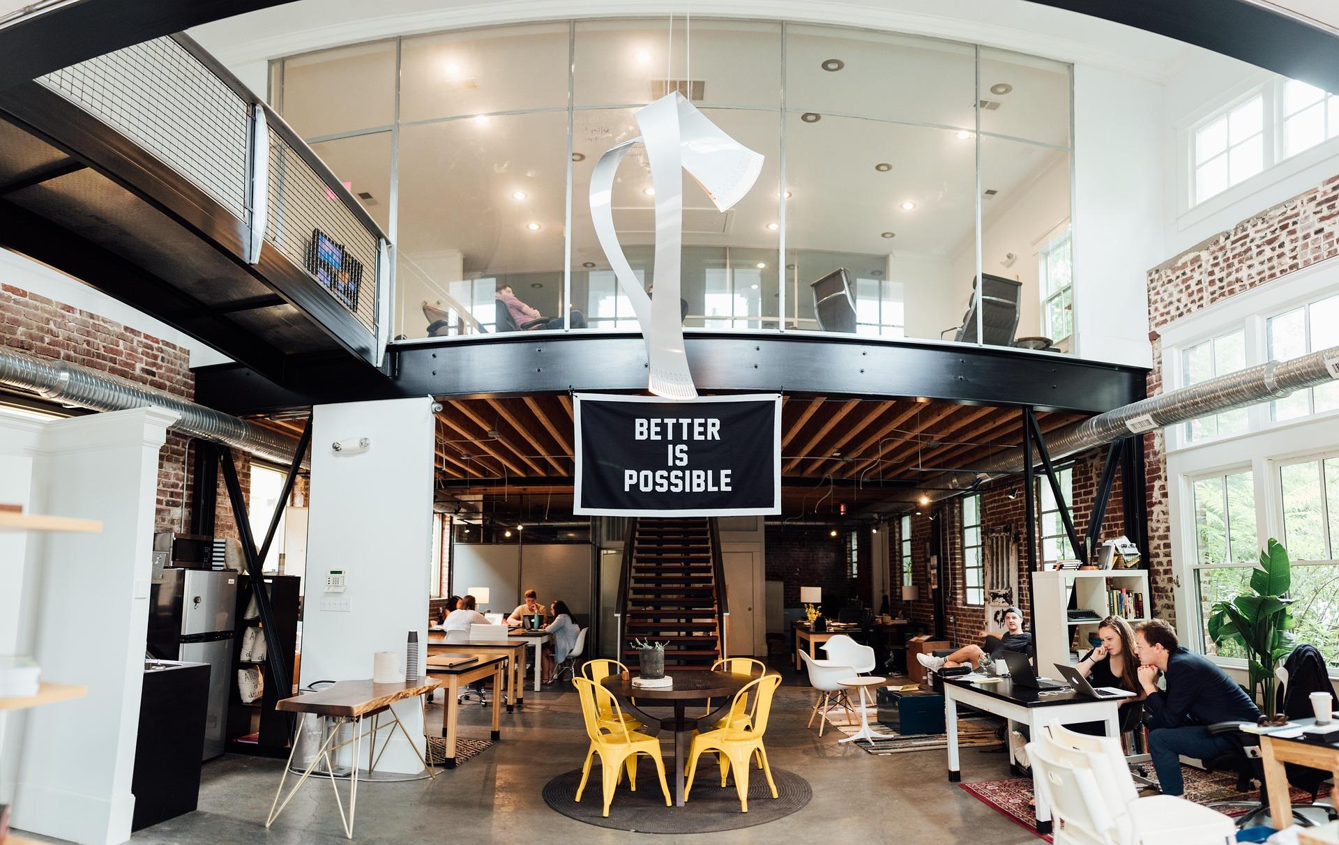 Espace de travail lumineux avec plusieurs personnes réunies dans des bureaux ouverts.